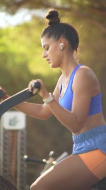 Formda bir kadın açık havada bisiklet sürüyor. Güneşli bir yerde azmini ve gücünü gösteriyor.