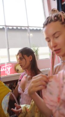 İki şık kadın, hayat ve renk dolu, canlı ve modaya uygun bir ortamda eşsiz giysiler keşfediyor.