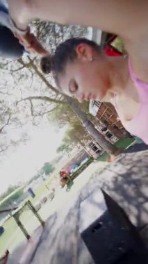 Çeşitli kettlebell dayanıklılık tekniklerini gösteren canlı bir açık hava egzersiz sahnesi.