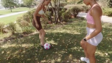 En iyi iki arkadaş güneşli bir parkta eğlenceli ve takım çalışması ruhlarını sergileyerek eğlenceli bir futbol maçının keyfini çıkarıyorlar.