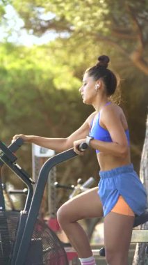 Bir kadının açık havada egzersiz yaptığı, spor yaptığı, spor yaptığı ve modern sağlıklı yaşam tarzını sergilediği canlı bir sahne.