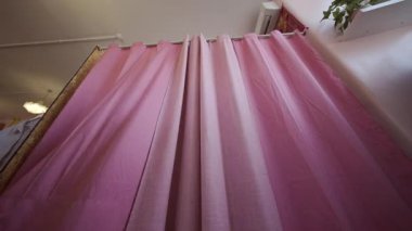 İki kadın giyinme odasında canlı renkler ve stiller sergileyen kıyafet seçeneklerini hevesle araştırıyor.