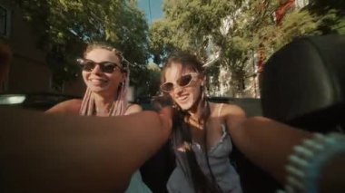 İki arkadaş gezintileri sırasında sıcak güneşin altında keyifli anları yakalayan üstü açık bir yolculuktan hoşlanırlar.