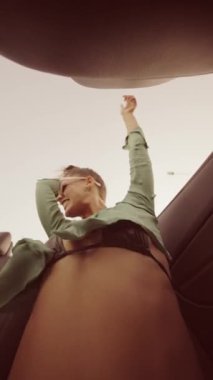 Canlı ve hayat dolu bir sahne bir arabada otururken bir kadını sevinçle kutlarken yakalıyor. Yaz eğlence temaları için mükemmel