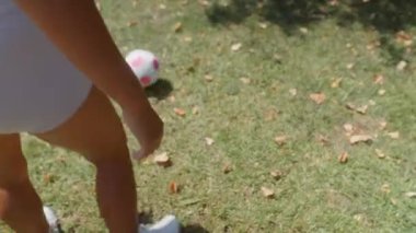 İki yakın arkadaş parkta futbol oynarken güneşli bir günün tadını çıkarıyorlar.