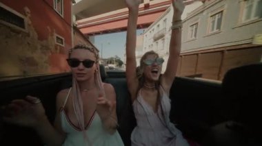 İki arkadaş güneş altında üstü açık bir yolculuğun tadını çıkarıyorlar. Gençliklerini ve özgürlüklerini kucaklıyorlar.