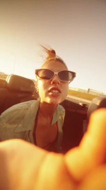 Sıcak, güneşli bir günde üstü açık şık bir arabanın içinde özgürlüğe ve eğlenceye kucak açan canlı bir an.