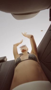 Üstü açık bir arabada sıcak güneş ışığı ve saf mutluluğu kucaklayarak geçirilen hoş ve kaygısız bir an.