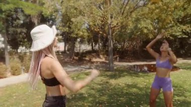 İki arkadaş, güzel bir günde, sıcak güneşin altında enerjik bir top oyunu oynuyorlar.