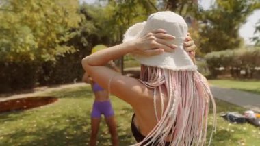 İki hevesli kadın aktif olarak açık havada antrenman yapıyor, enerjik bir şekilde bir sağlık topu fırlatıyor.