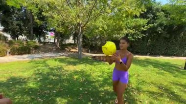 İki neşeli kız, hareketli bir parkta aktif olarak egzersiz yaparken birlikte eğlenceli bir anın tadını çıkarıyorlar.