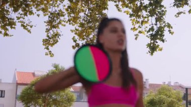 Bir kadın, etkileyici atletizmini ve coşkulu ruhunu sergileyerek parkta canlı bir oyun oynamaktan mutlu olur.
