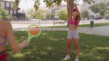 Parkta eğlenceli ve eğlenceli bir gün geçirirken raketlerle oynarken ve canlı renklerle çevriliyken