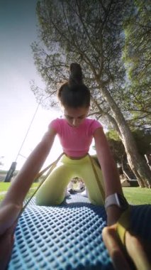 Genç bir atlet dinamik bir esneme seansına katılır, aktif yaşam tarzı ve uygunluğu vurgular..