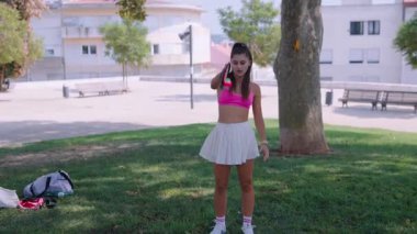 Güneşli bir günde, iki iyi arkadaş canlı kıyafetler içinde parkta canlı bir oyun oynamaktan zevk alırlar.