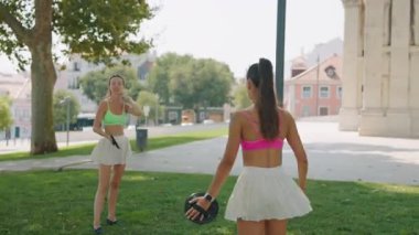 Güneşli bir günde, iki arkadaş yemyeşil bir parkta renkli disklerin keyfini çıkarıyorlar.