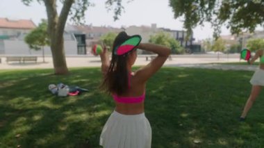 İki yakın arkadaş neşeli bir şekilde parkta güneşli bir günün tadını çıkarıyorlar. Saf neşe ve kaygısız yaz atmosferini somutlaştırıyorlar.