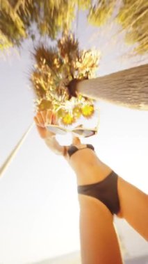 Sahilde geçen neşeli bir yaz anı, mükemmel bir şekilde gösterişli stil, güneş ışığı ve son moda güneş gözlükleri.