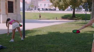 Güneşli bir günde neşeli bir açık hava sporuna katılan iki arkadaş canlı ve şık kıyafetler sergiliyorlar..