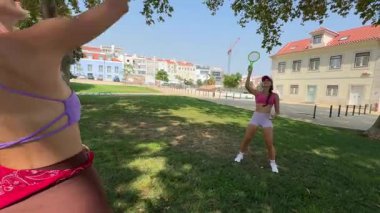 İki yakın arkadaş parkta eğleniyor, frizbi oynuyor ve güneşin altında harika vakit geçiriyorlar.