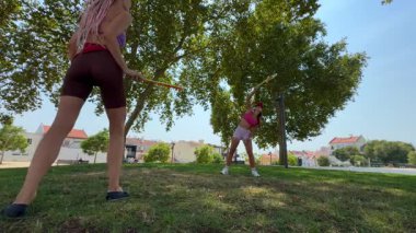 İki neşeli arkadaş dışarıda keyifli bir gün geçiriyorlar. Parlak, güneşli ağaçların altında yakalamaca oynuyorlar.