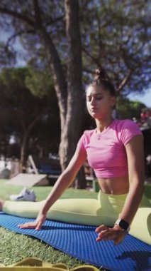 Genç bir kadın dışarıda esneme egzersizleri yapıyor, enerjik ve enerjik yaşam tarzını sergiliyor.