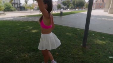 Neşeli bir kız enerjik bir şekilde canlı bir parkta oynuyor, heyecan verici yaz aktiviteleri ve hareketli açık hava titreşimleri sergiliyor.