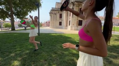 İki yakın arkadaş, açık havada güneşli ve davetkar bir parkta çeşitli eğlenceli aktivitelere katılıyor.