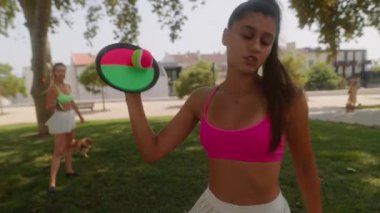 İki neşeli arkadaş güneşli bir parkta birlikte spor yapıyor, fitness ve arkadaşlıklarını destekliyorlar.