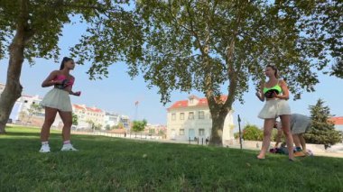 Arkadaşlar keyifli bir şekilde güneşli bir parkta spor yapıyorlar. Formlarını ve güçlü dostluklarını kutluyorlar.