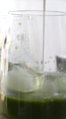 Buzun üzerine dökülen yeşil bir içkinin görkemli görüntüleri, canlı tatlar ve sağlık faydaları sergiliyor..