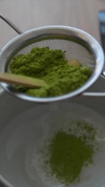 Usta, yüksek kaliteli yeşil çay tozunu en uygun lezzet için dikkatlice elemek suretiyle karmaşık bir matcha hazırlama sanatı.