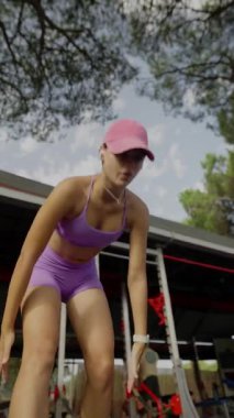 Canlı bir açık hava antrenmanında şık ve modaya uygun giyinmiş bir fitness meraklısı yer alıyor.