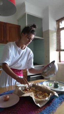 Bir kadın keyifle sıcak mutfağında leziz bir yemek hazırlar, pozitif ve canlı bir mutfak enerjisi yayar.