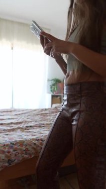 Modern yatak odası ortamında modaya uygun ve şık giysiler içeren şık ve şık bir anı yakalamak.