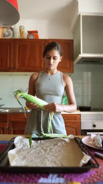 Parlak ve davetkar bir mutfak ortamında genç bir kadın ustalıkla taze mısırı hazırlıyor.