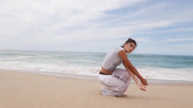 Zarif bir dansçı akıcı bir şekilde hareket eder okyanus dalgalarının ritmiyle yavaşça kumlu sahilde tur atar.