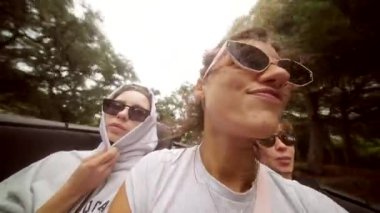 Üç iyi arkadaş, bulutlu bir günde üstü açık bir arabayla giderken neşe dolu anları yakalar.