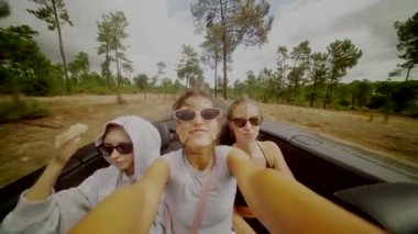 Üç iyi arkadaş bulutlu bir gökyüzünün altında üstü açık bir arabada heyecan verici ve unutulmaz bir yolculuğun tadını çıkarıyorlar.