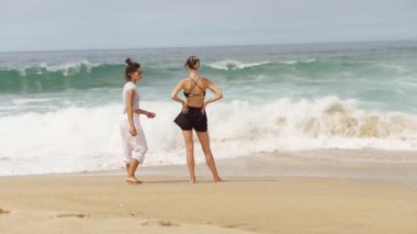 İki yakın arkadaş kumsalın tadını çıkarıyor, dalgalar ve güneş ışığını kucaklıyor, birlikte unutulmaz anılar yaratıyorlar.