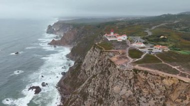 Nefes kesen bir hava manzarası dramatik uçurumlar ve karamsar bir okyanus zeminine kurulmuş pitoresk bir deniz feneri