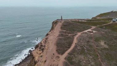 Muhteşem bir kıyı manzarası manzaralı bir yol, tarihi bir anıt ve geniş bir okyanus zeminine sahip.