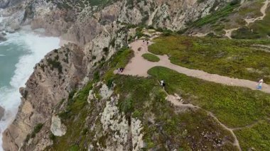 Göz kamaştırıcı hava görüntüleri güzel manzaralı uçurumlar, yemyeşil alanlar ve okyanus boyunca dolambaçlı yollar.