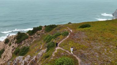 Okyanus dalgalarının yanında yer alan güzel sahil şeridi boyunca büyüleyici bir yürüyüş yapmaktan zevk alıyor.