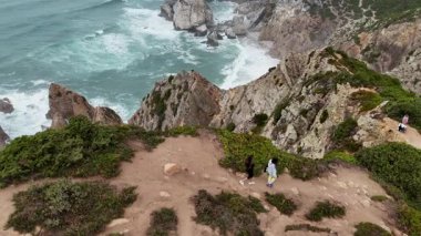 Nefes kesici bir hava manzarası engebeli bir kıyı şeridini yakalar yürüyüş yolları ve çarpan okyanus dalgalarıyla süslenir.