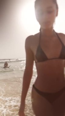 Neşeli sahnelerle dolu canlı bir sahil sahnesi. Güzel okyanusun ışıl ışıl güneşinin ve neşesinin altında.