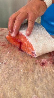 Yetenekli bir profesyonel somon filetosu sanatının incelikli tekniklerini ve yöntemlerini ustalıkla gösterir.