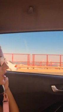 Göz kamaştırıcı güzellikte bir manzaranın ortasında genç bir kadını gösteren bir araba penceresinden kesinlikle büyüleyici bir manzara.