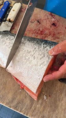 Keskin balık kesme tekniklerini gösteren, zengin dokuları vurgulayan ve yetenekli bıçak işi yapan bir uzmana bakın.