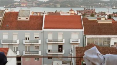 Güzel bir günbatımı çatılara canlı renkler saçar, göz kamaştırıcı bir mimari ve yakınlardaki parlak suları gösterir.